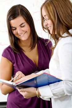Two women discussing something in a notebook.jpg