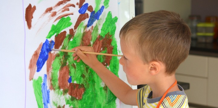 Boy painting at easel