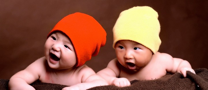 Smiling infants wearing hats